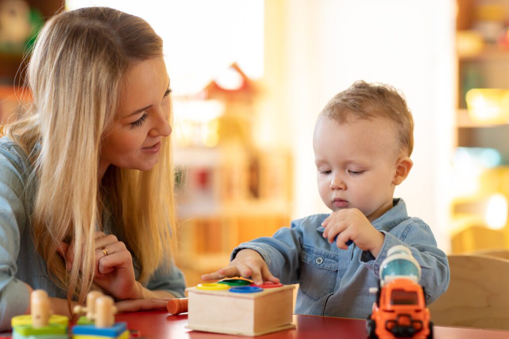 A Woman and Child Happily Playing with Toys in a Classroom