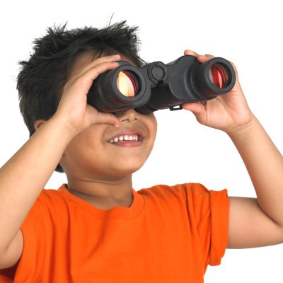 A Young Boy in an Orange Shirt Gazes Through Binoculars